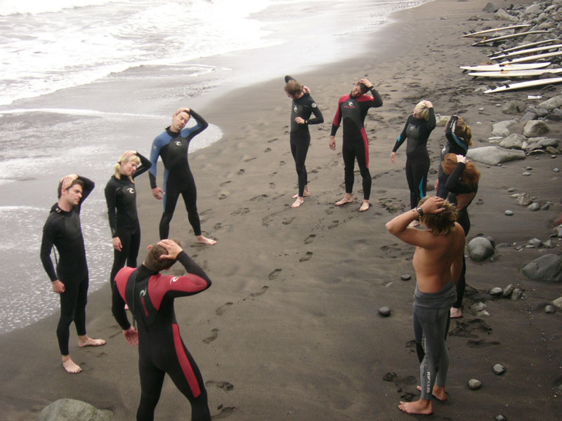 People in wetsuits exercise on the beach in Tenerife.