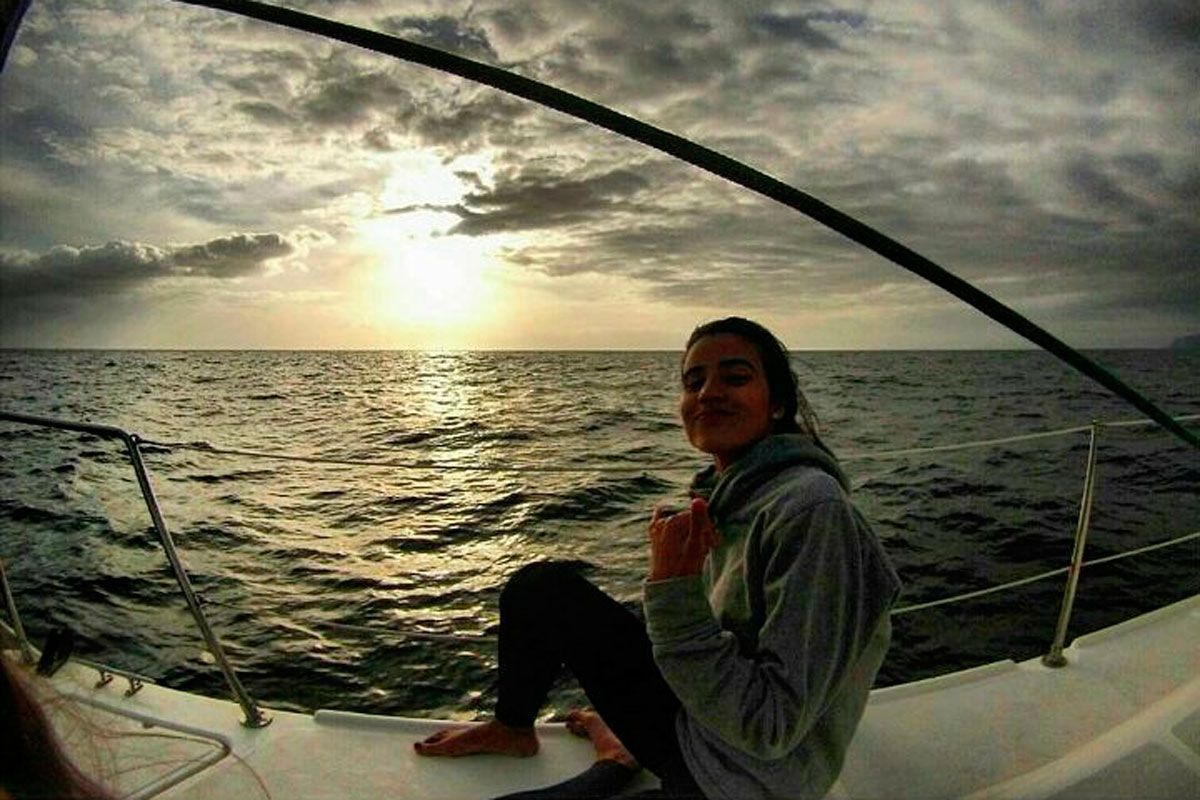 Person sitting on a boat at sunset near the coast of Tenerife.