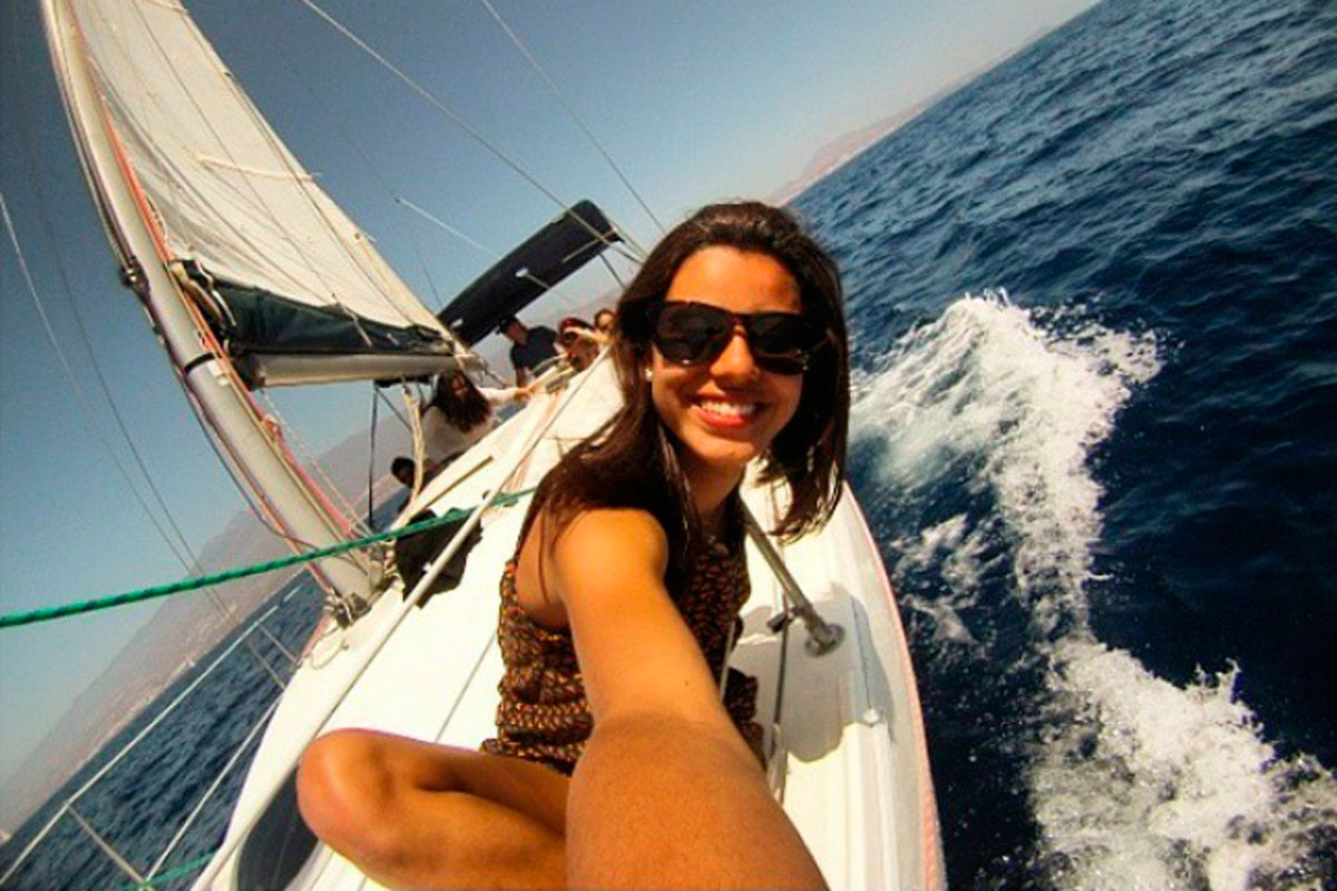 Person smiling on a sailboat sailing near the coast of Tenerife.