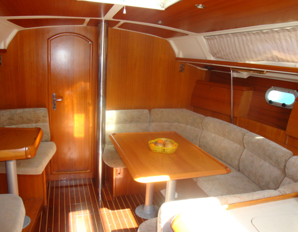 Interior of a yacht with wooden table and padded seats in Tenerife.