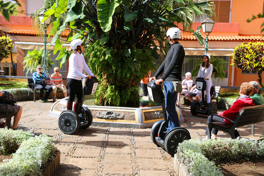 People on segways around a fountain in a square in Tenerife.