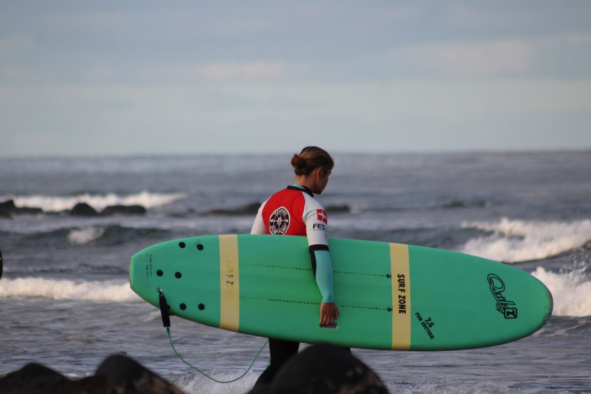 person with green surfboard on the beach in Tenerife