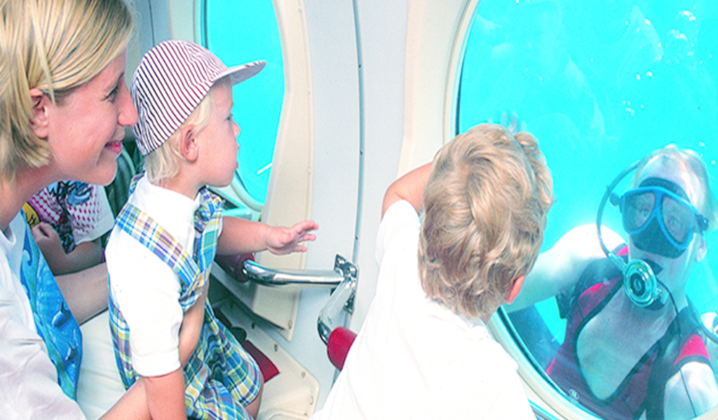 Family watches diver from submarine in Tenerife.