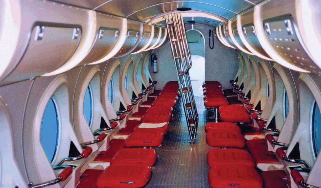 Interior of a tourist submarine in Tenerife with red seats and large windows.