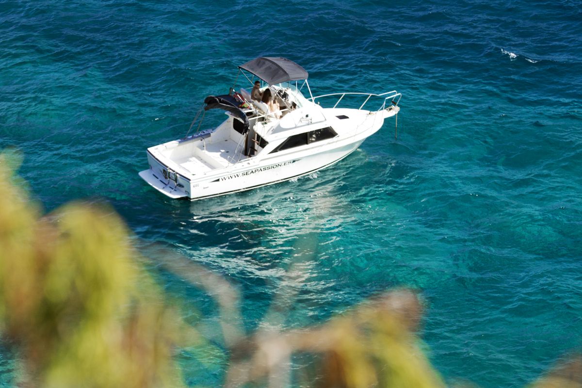 Boat sailing in the blue waters of Tenerife with people on board.