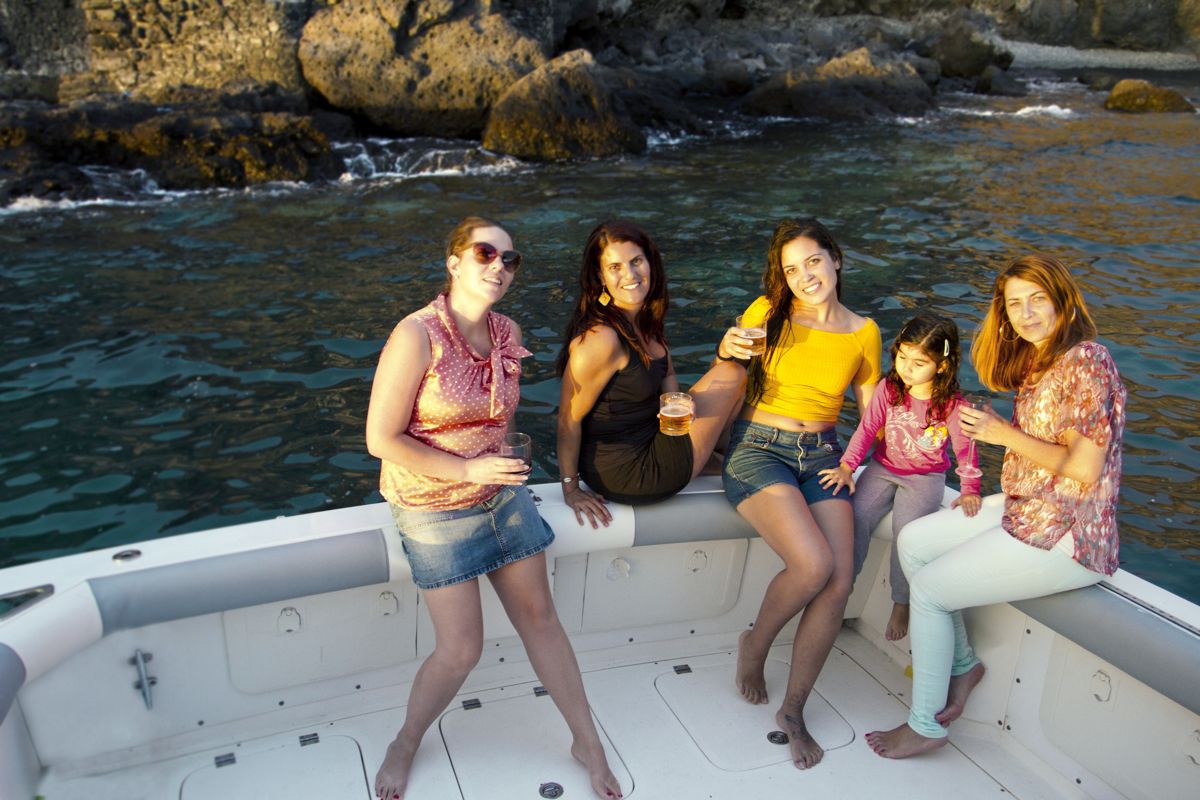 Group of people on a boat along the coast of Tenerife, enjoying the sunset.