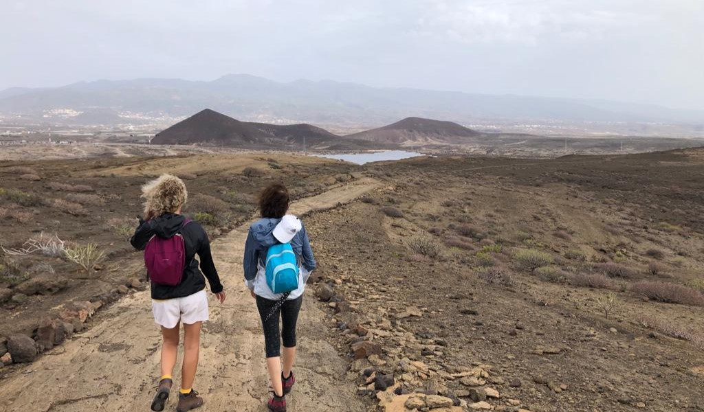 Two people walking along a path in the landscape of Tenerife.