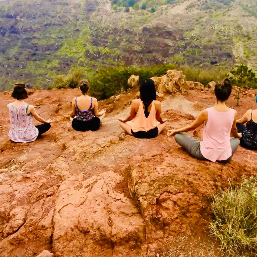People meditating outdoors on a cliff in Tenerife.