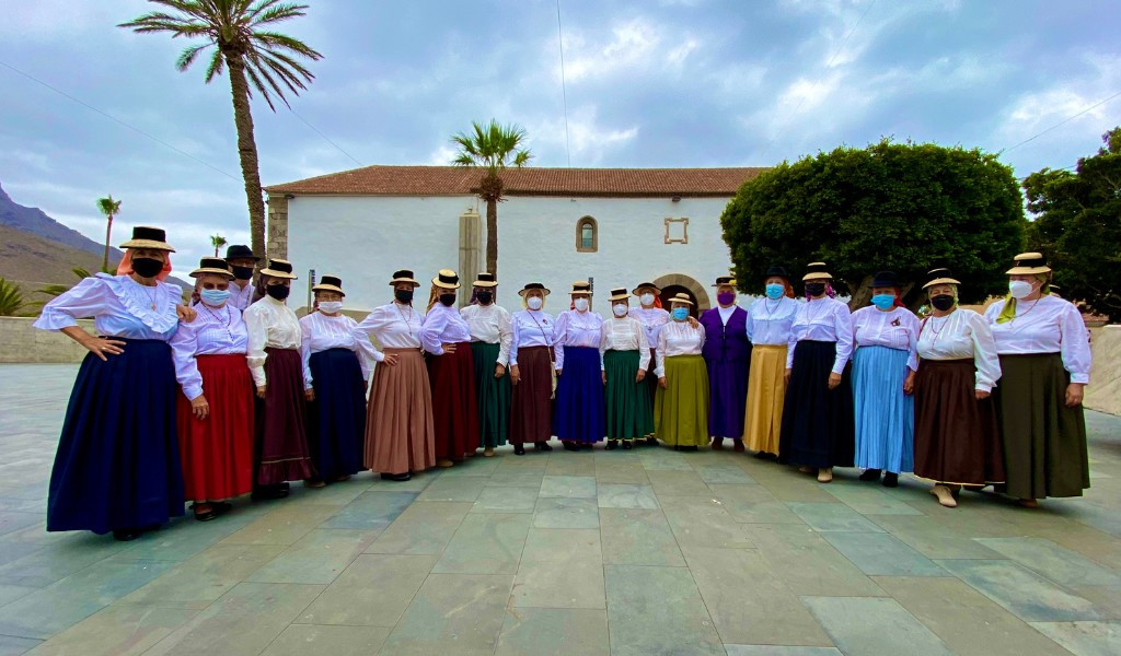 Group of people in traditional costumes in La Gomera, Tenerife, in front of a building.
