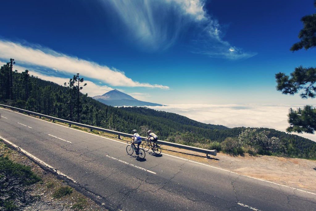 Cyclists on the road with a view of Mount Teide in Tenerife.