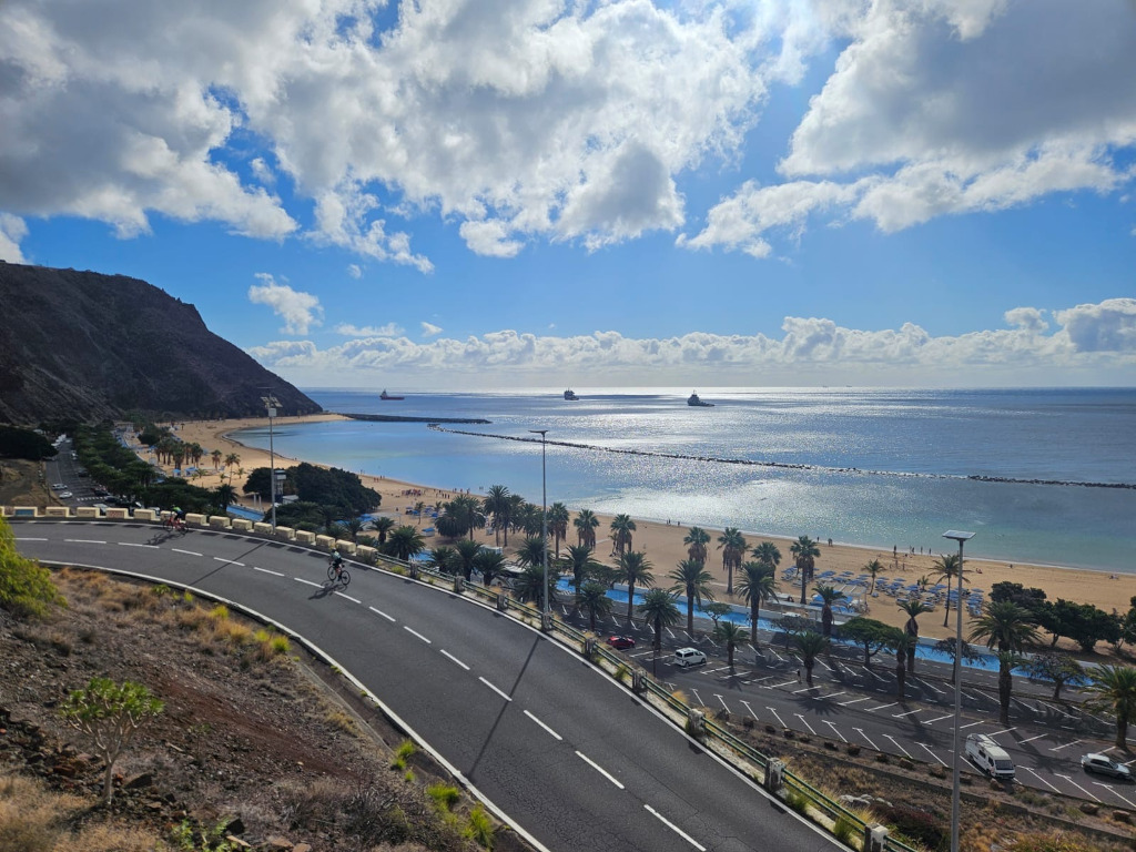 Las Teresitas beach in Tenerife with cyclists on the road and sea view.
