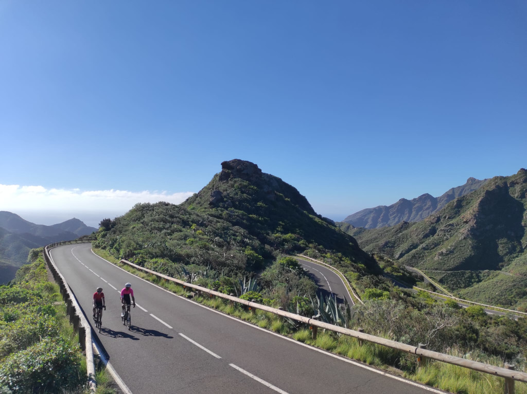Two cyclists ride along a winding road in the mountains of Tenerife.