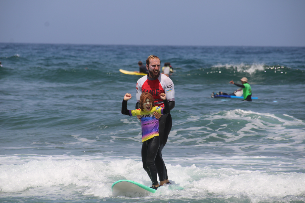Adult and child surfer in surf lesson on a beach in Tenerife.