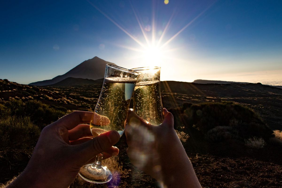 Toast with glasses of champagne at sunset near Mount Teide, Tenerife.