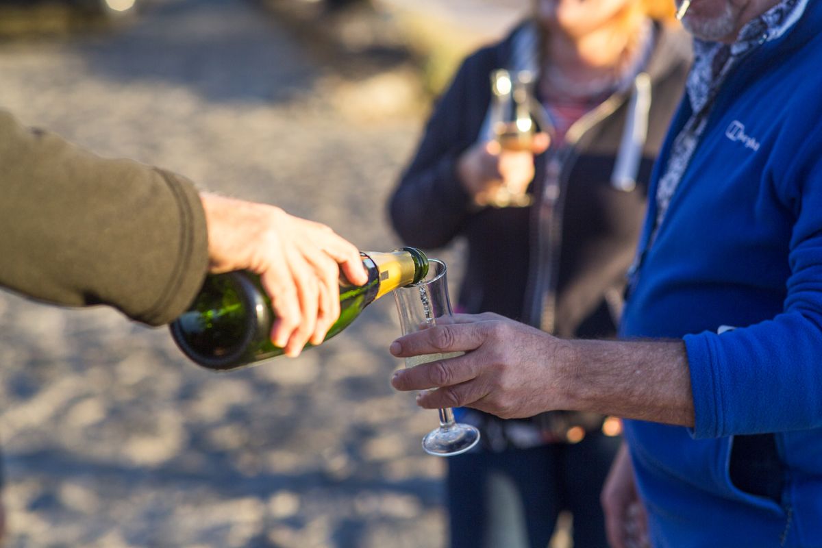 Pouring champagne into a glass on the beach in Tenerife.