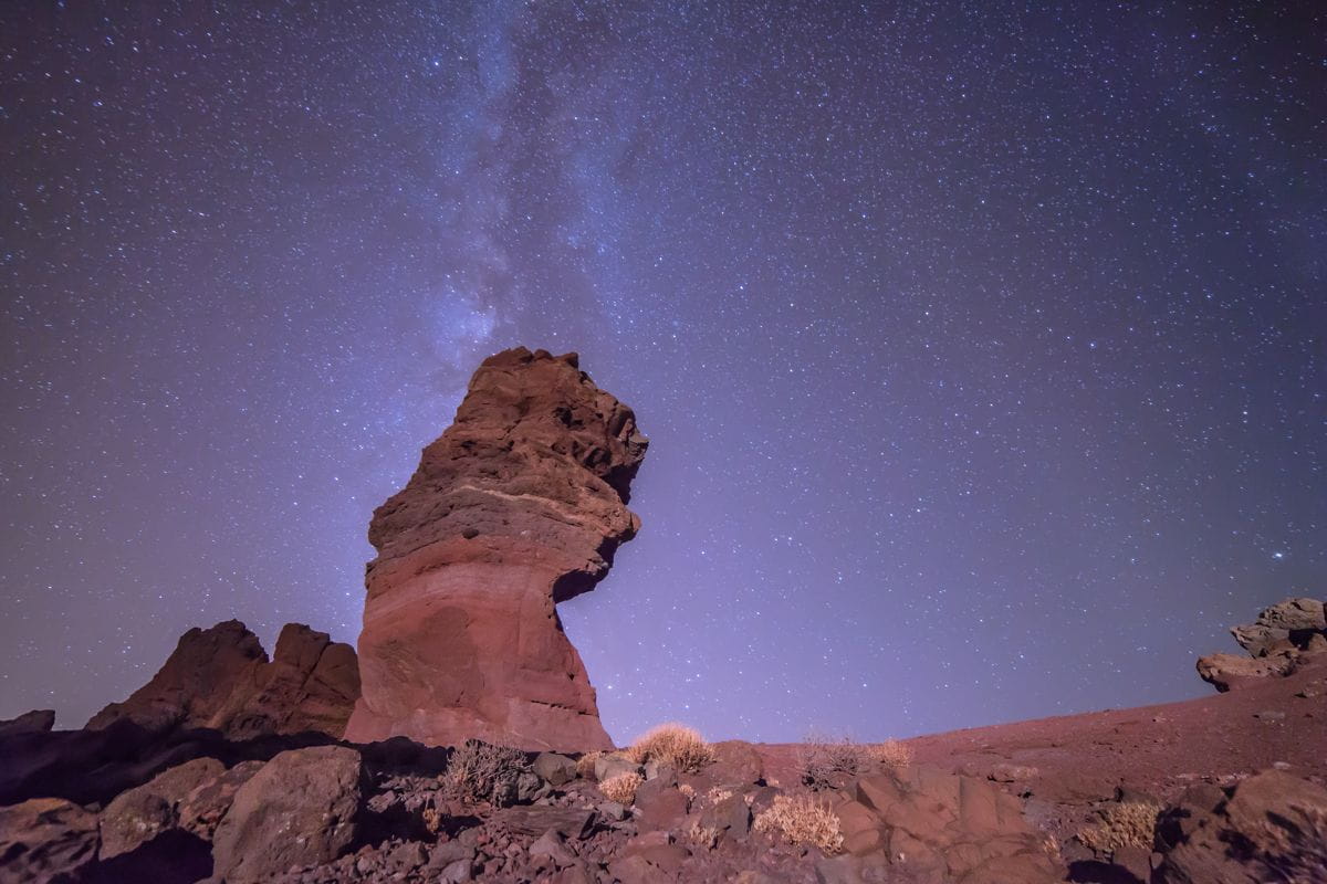 Starry sky over Mount Teide in Tenerife with prominent rock formation.