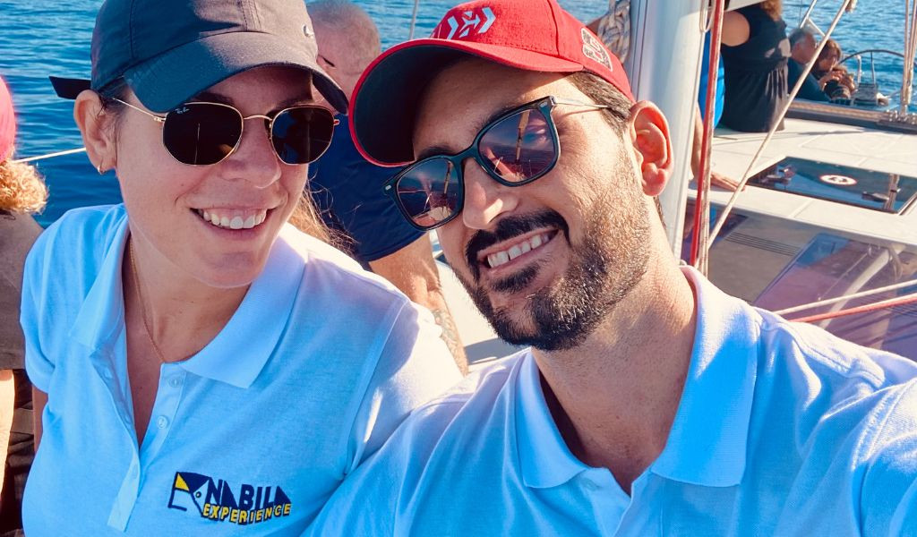 People smiling on a boat in Tenerife, with Anaga Experience logo on a T-shirt.
