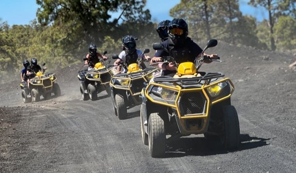 People driving off-road vehicles on a dirt road in Tenerife.