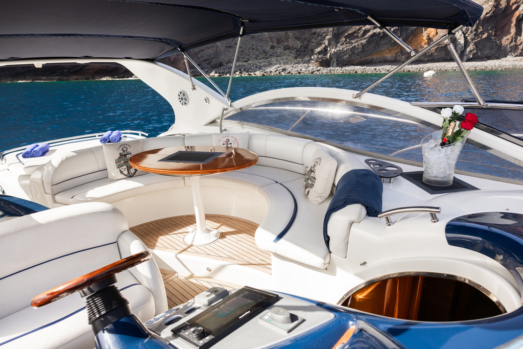 Yacht interior with white leather seats and round table on the coast of Tenerife.