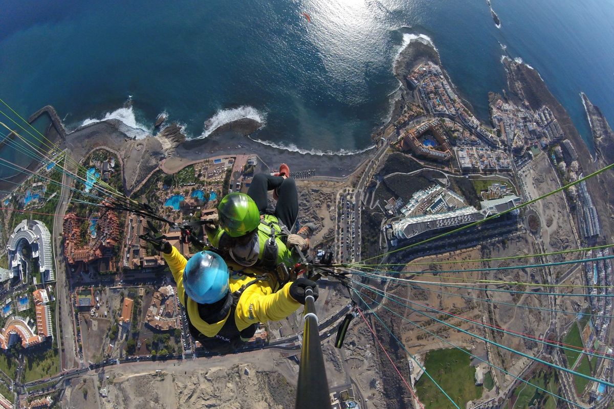 Paragliding over Costa Adeje in Tenerife with a view of the ocean and the coast.