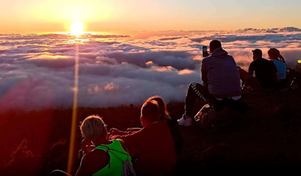 People enjoying the sunset over the clouds on Mount Teide, Tenerife.
