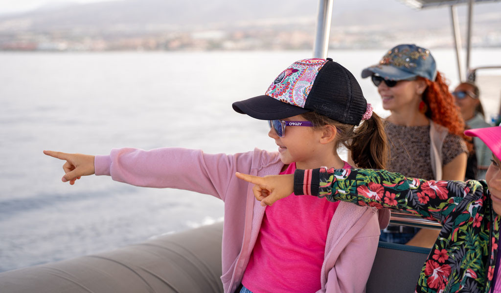 Girls pointing from a boat on the coast of Tenerife.