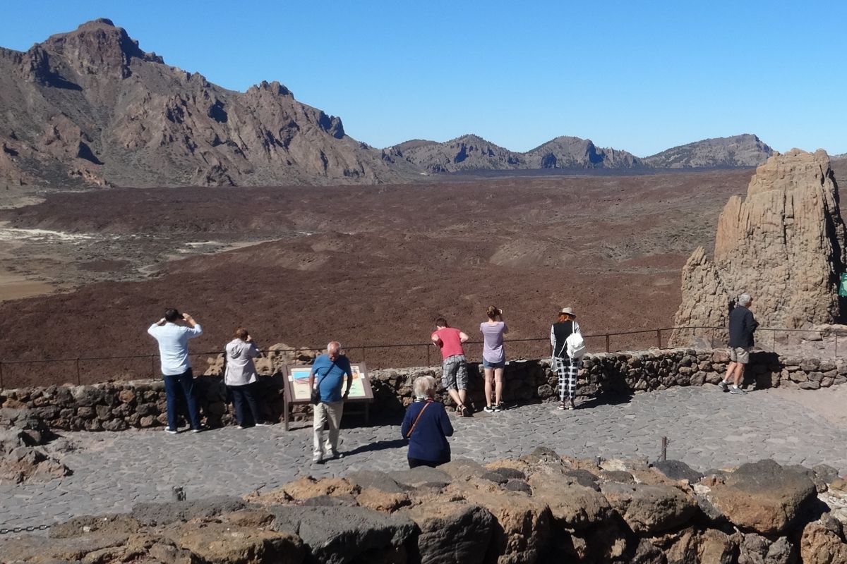 People observing the volcanic landscape of Mount Teide in Tenerife.