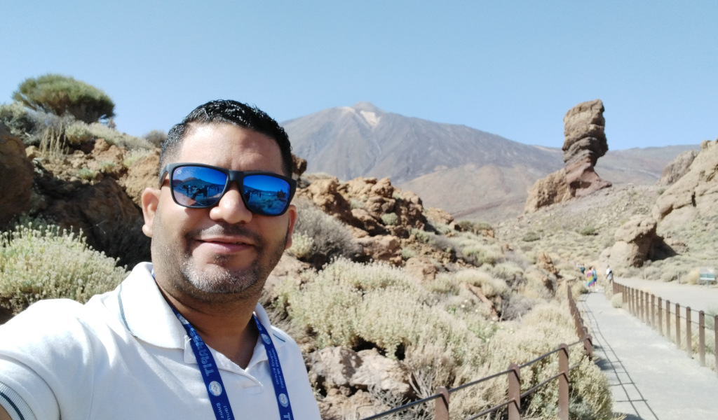 Person wearing sunglasses in Teide National Park, Tenerife. Mountain and rock formation behind.