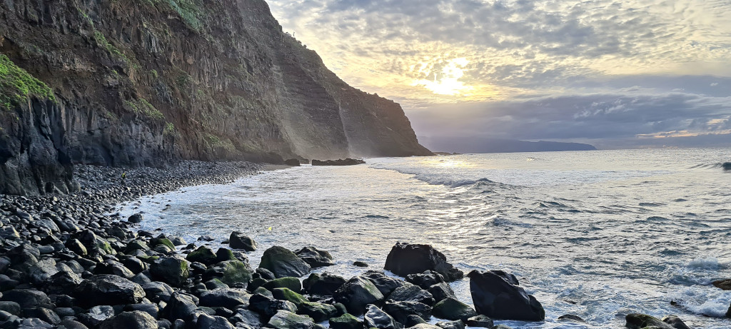 Rocky coastline at sunset in Tenerife with cliffs and calm sea.