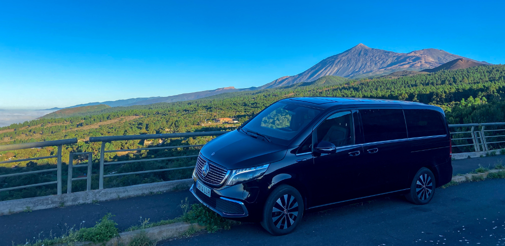 Black vehicle with Teide background in Tenerife under a clear sky.