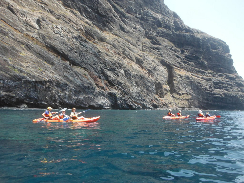 People kayaking in front of the cliffs of Los Gigantes in Tenerife.