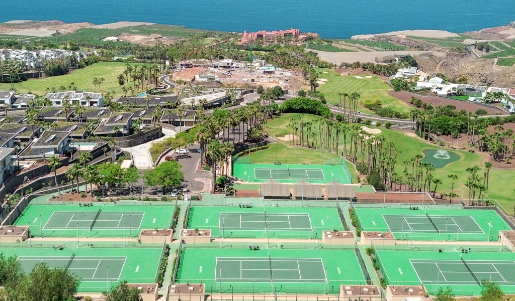 Aerial view of tennis courts and golf course in Tenerife by the sea.