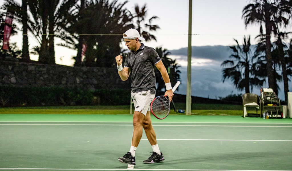 Tennis player celebrating on the outdoor court in Tenerife at sunset.