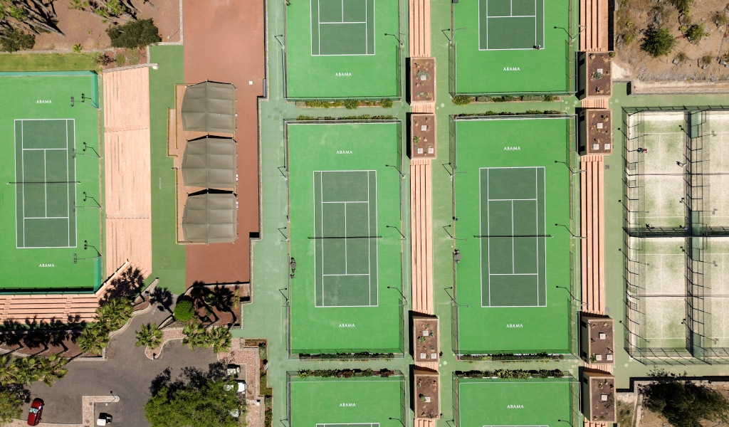 Aerial view of tennis courts in Abama, Tenerife, surrounded by greenery and rest areas.