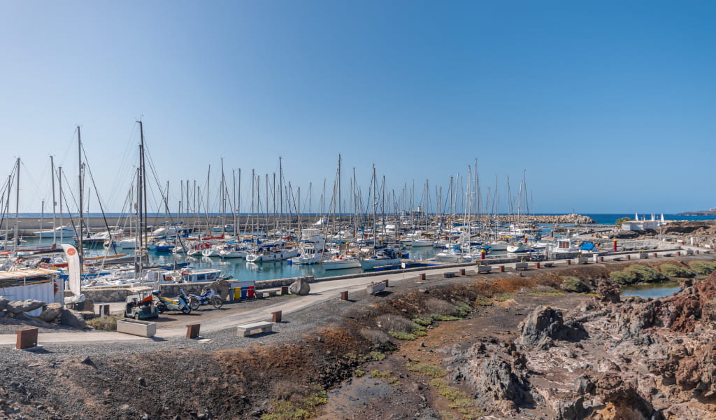 Port of Los Gigantes in Tenerife with docked boats and blue sea.