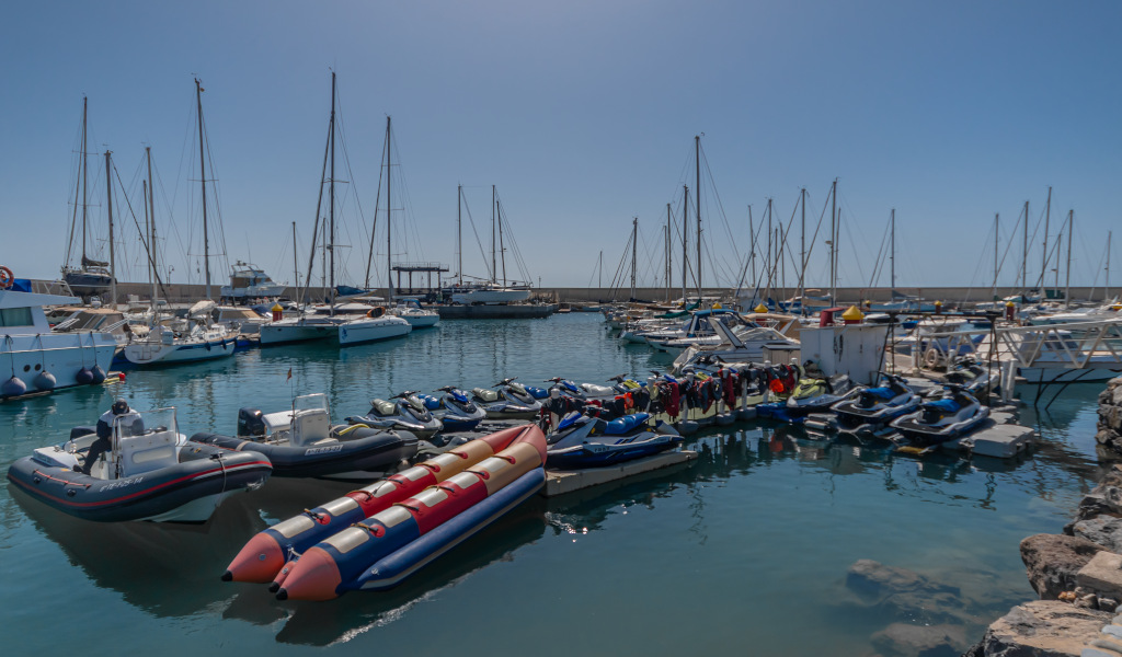 Jet skis and boats docked in the port of Tenerife.