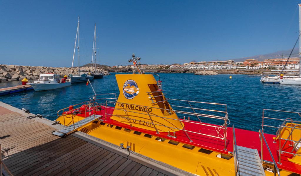 Yellow submarine docked in the port of Puerto de la Cruz, Tenerife, with boats in the background.