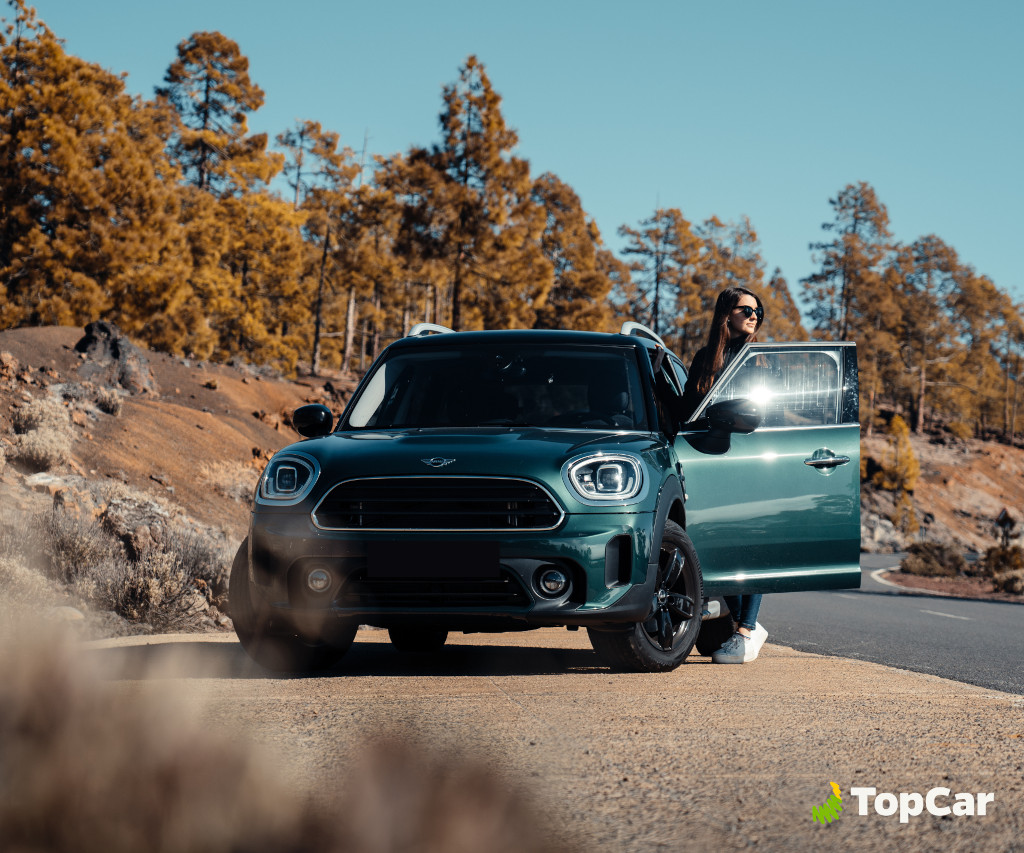 Car on mountain road in Tenerife with person by the open door.