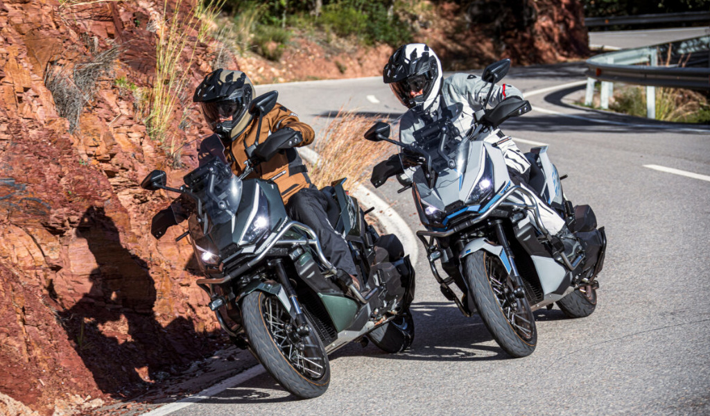 Two motorcyclists on a curved road with a rocky bottom in Tenerife.