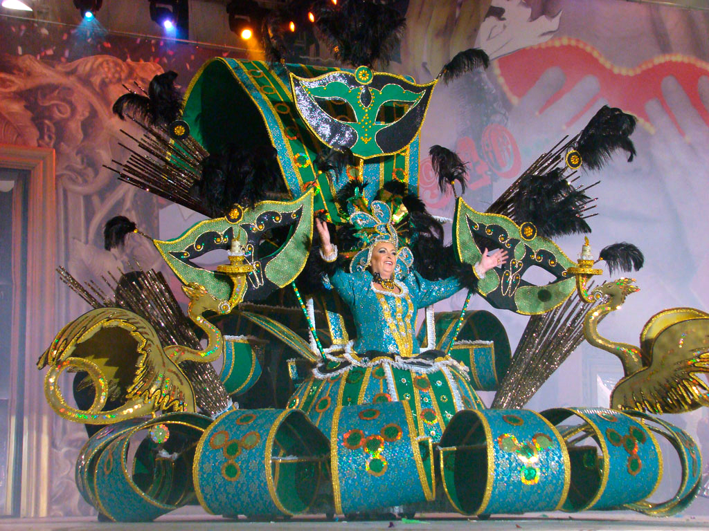 Person in colorful costume with masks and feathers during the carnival in Tenerife.