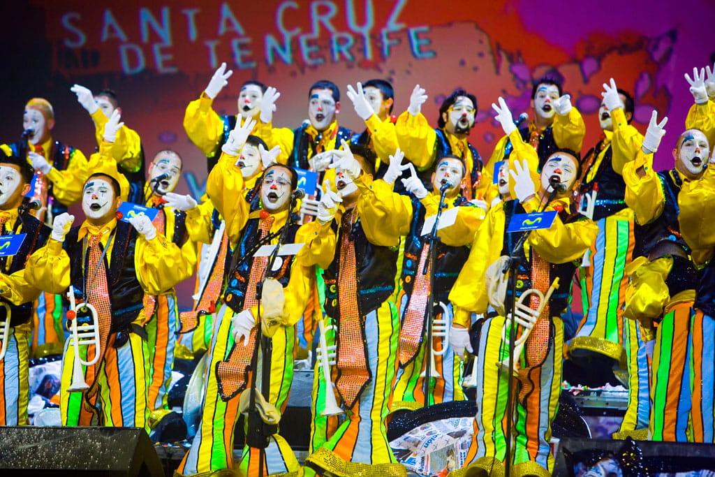 People dressed up as colorful mimes sing at the Carnival of Santa Cruz de Tenerife.