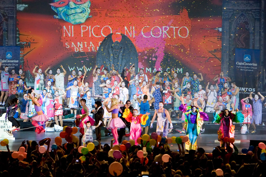 People in costume at the Carnival of Santa Cruz de Tenerife. Includes the text NEITHER PICO NOR CORTO.