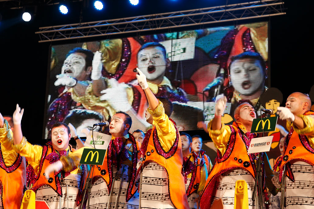 Musical performance during a carnival in Tenerife with colorful costumes and group singing.