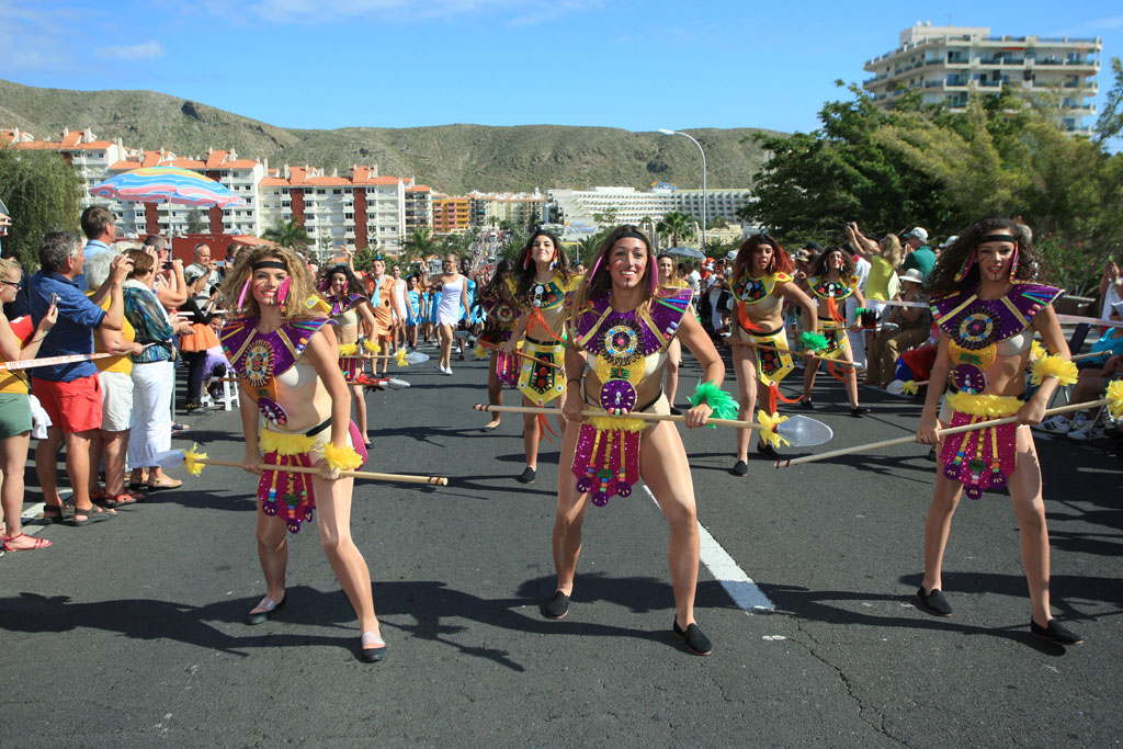 People in costumes dance in a parade on the main street of Los Cristianos, Tenerife.