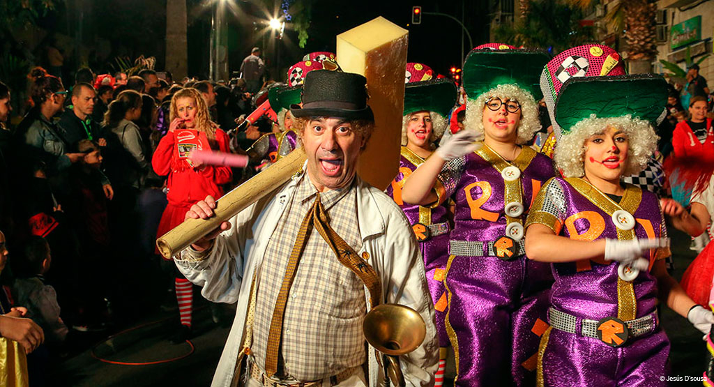 People in colorful costumes parading at a carnival in Santa Cruz de Tenerife.