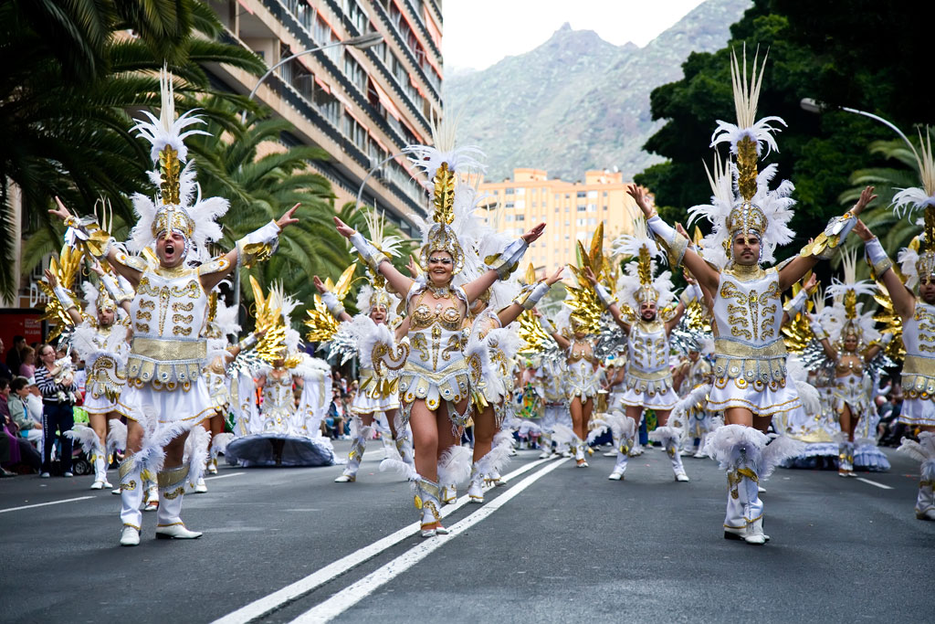 Group of people in gold and white carnival costume parading in Santa Cruz de Tenerife.