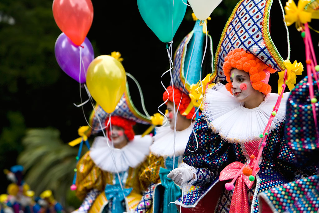 People dressed as mimes with colorful balloons at a parade in Tenerife.