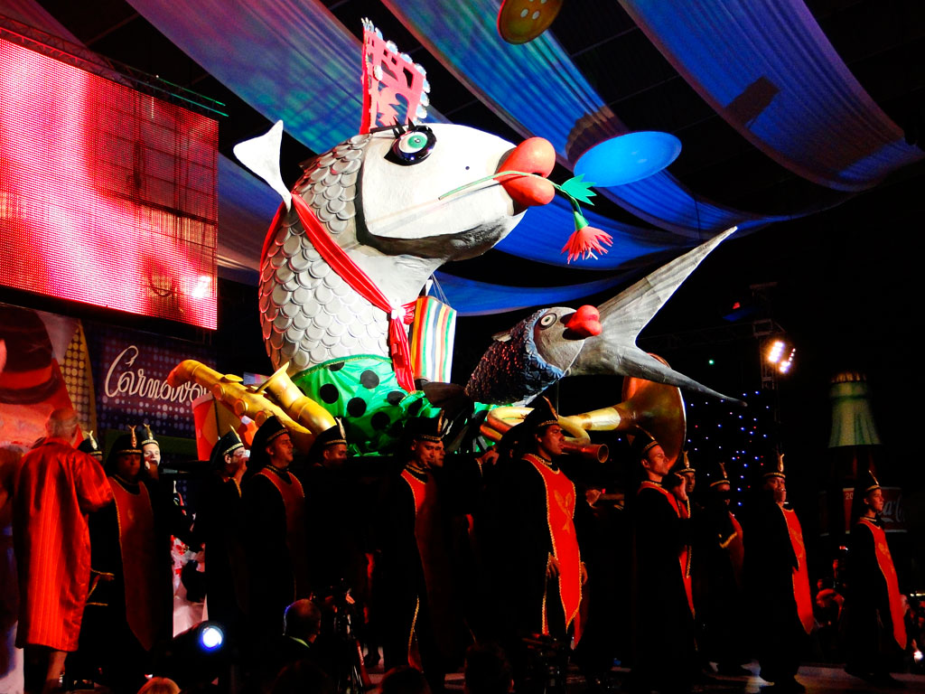 Fish float at the Carnival of Tenerife, surrounded by people in costumes.