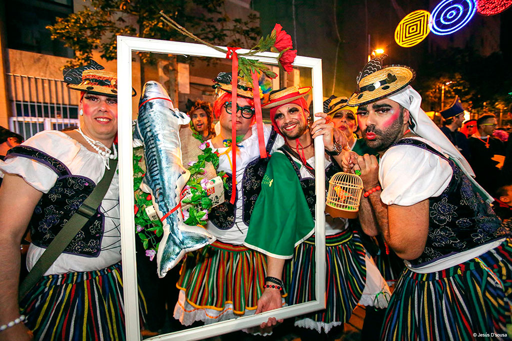 Group at Tenerife carnival with colorful costumes and a decorated frame.