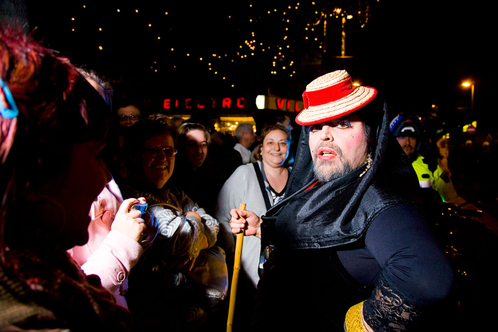 Person in costume and group celebrating at night in Santa Cruz de Tenerife.